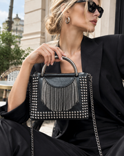 Noir Cascade Handbag: matte black studded handbag with a waterfall of metal fringe, a chunky ring handle and a curb-chain strap
